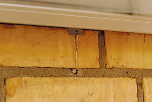 Bild 10:15 Infästning av fönsterbleck med trådklammer före putsning av fasaden. Trådklammer ska utföras som figur 10:51.  Foto: Torbjörn Osterling