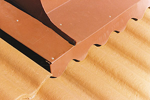 Bild 10:18. Vinge över takpannetak på framstycke till skorstensbeslag kompletterad med ett profilklippt beslag.